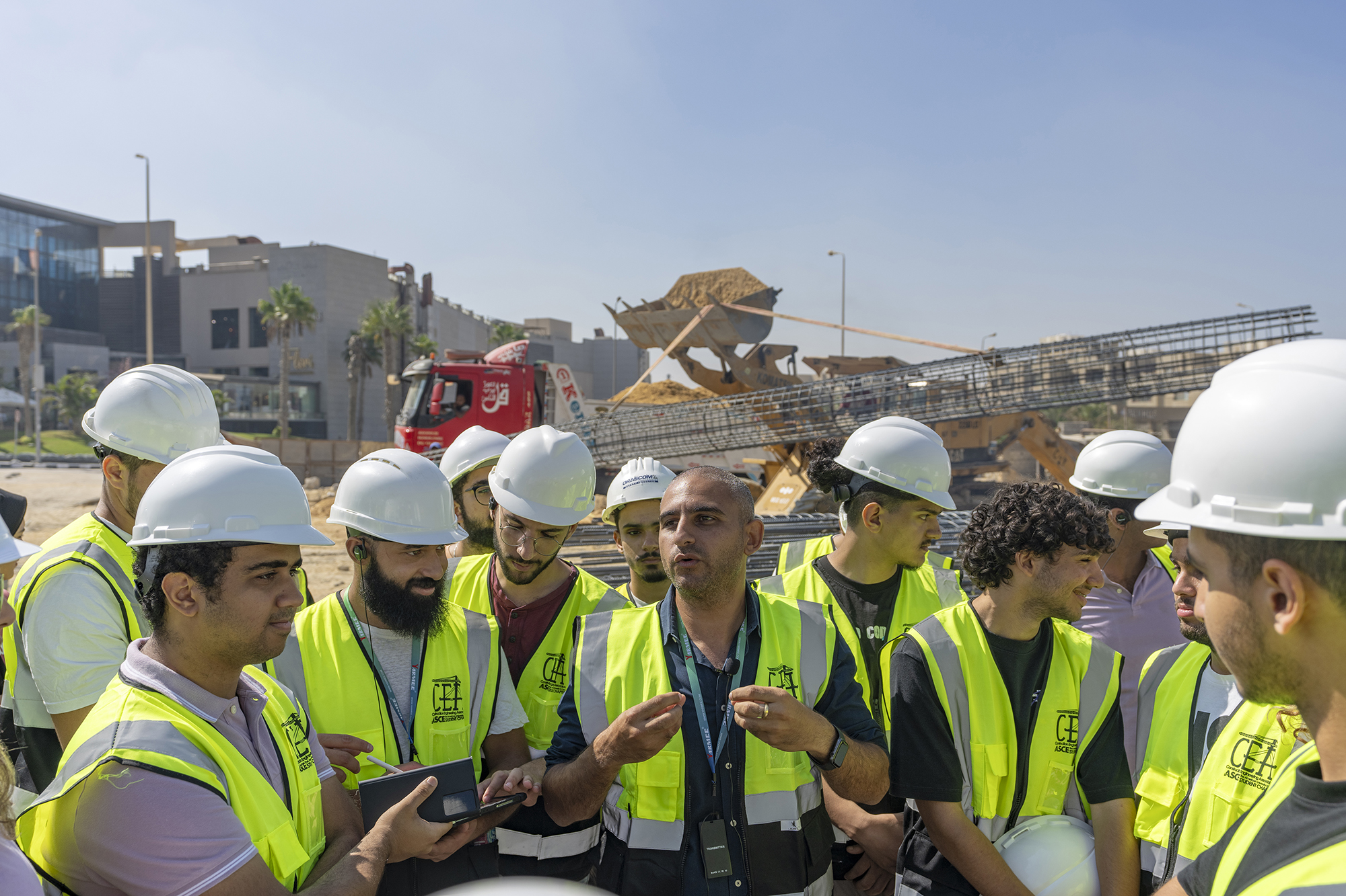 A group engineering students on site wearing a vest and helmet