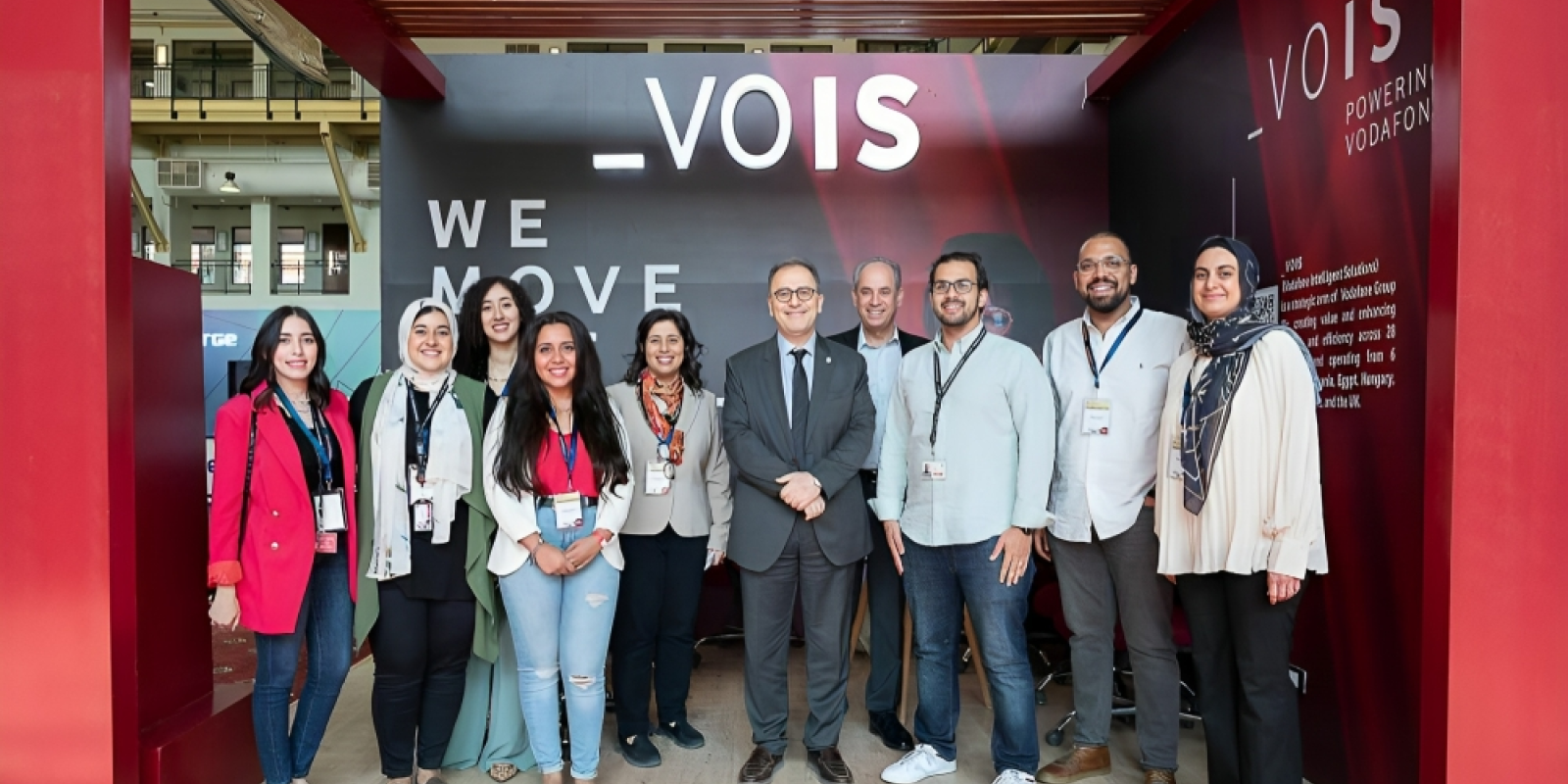 A group of girls and boys taking a group picture with AUC president Ahmad Dallal