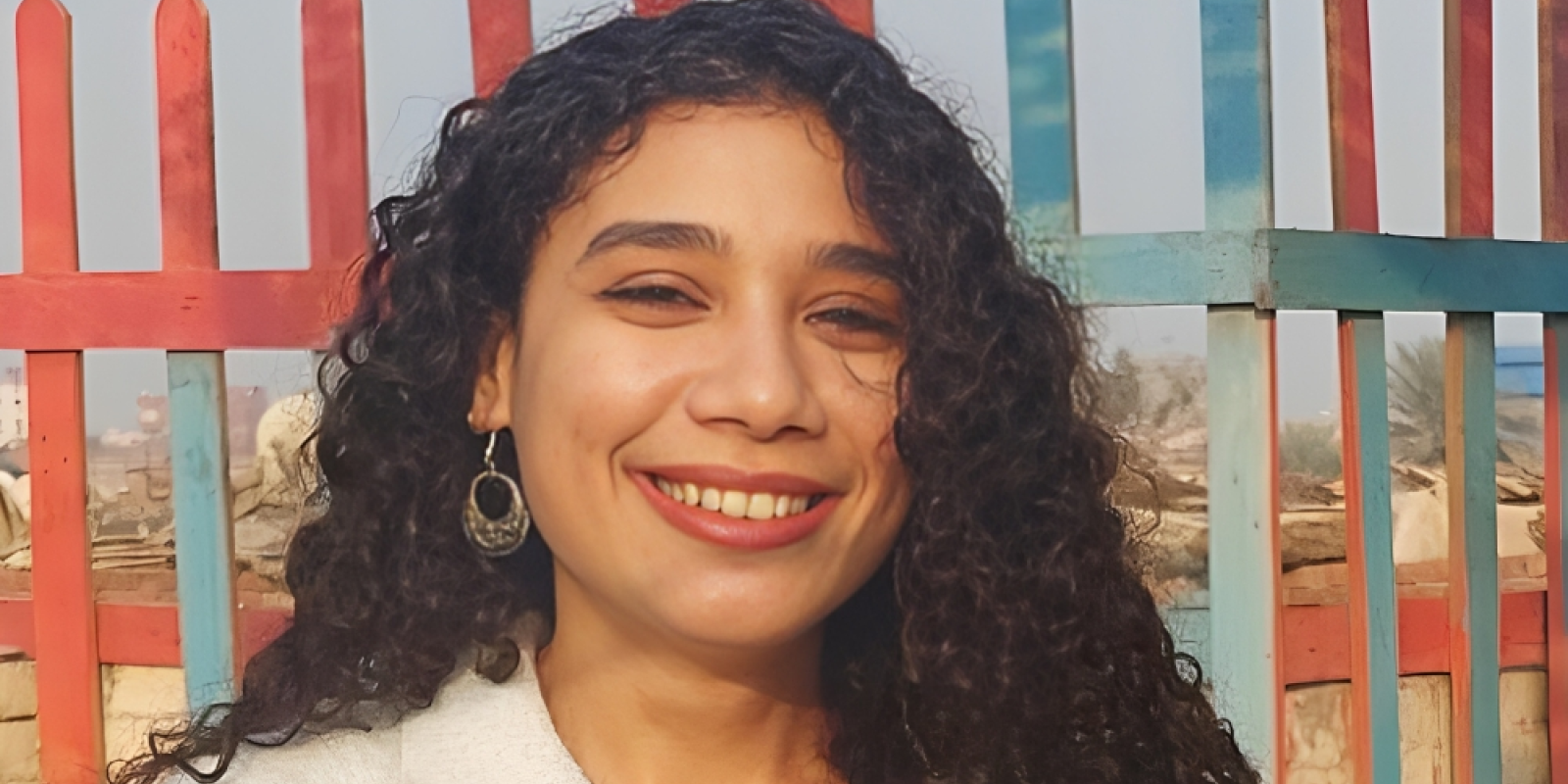 Headshot of a girl with curly hair smiling