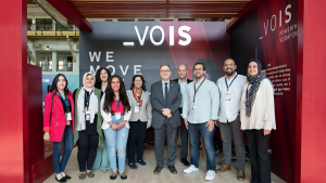 A group of girls and boys taking a group picture with AUC president Ahmad Dallal