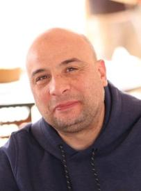 A middle-aged, fair-skinned man smiling.