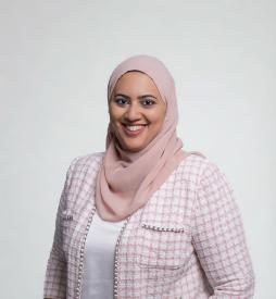 A veiled woman smiling and posing towards the camera. 